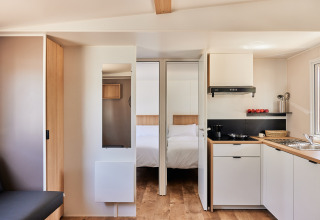 Interior moderno de cocina y dormitorio en Bungalow Premium Agave de TAIGA Almeria Playa, España.