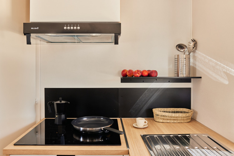 Kleine, moderne Küche im Bungalow Premium Agave bei TAIGA Almeria Playa mit Herd, und frischem Obst.