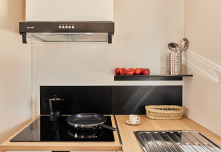 Moderna cocina pequeña en Bungalow Premium Agave, TAIGA Almeria Playa, con vitrocerámica, sartén y frutas.