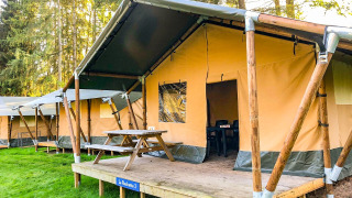 Tienda safari La Rochette en Beter Uit Holiday Park Walsdorf, Luxemburgo, con terraza de madera y mesa.