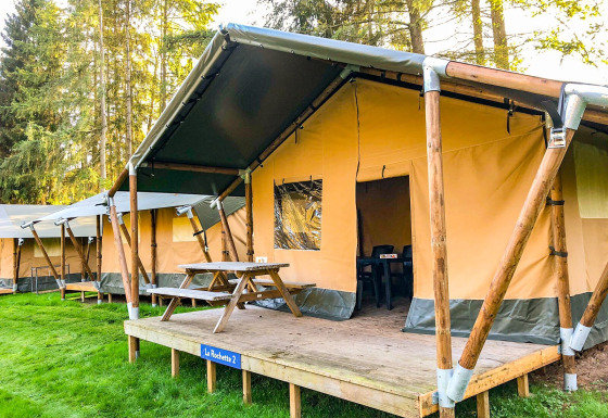 Tienda safari La Rochette en Beter Uit Holiday Park Walsdorf, Luxemburgo, con terraza de madera y mesa.