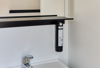 Moderno lavabo de baño con espejo y dispensador de jabón en Bungalow Premium Agave, TAIGA Almeria Playa, España.