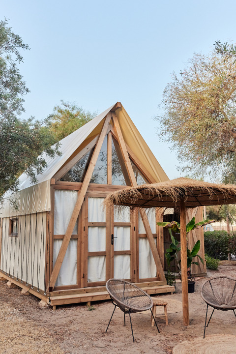 Tienda glamping Almanzora en TAIGA Almeria Playa, España, con estructura de madera y zona de estar exterior.