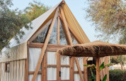 Safari-Glamping-Zelt Almanzora bei TAIGA Almeria Playa in Spanien mit Sitzbereich und Holzkonstruktion.