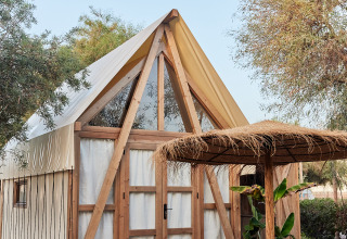 Tienda glamping Almanzora en TAIGA Almeria Playa, España, con estructura de madera y zona de estar exterior.