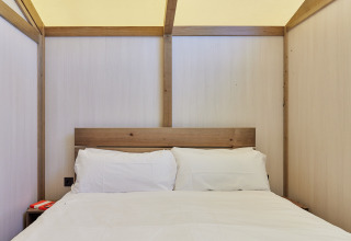 Innenaufnahme eines Bettes mit weißer Bettwäsche im Glamping Tent Alhamilla, TAIGA Almeria Playa, Spanien.