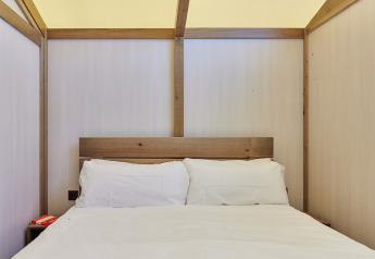 Innenaufnahme eines Bettes mit weißer Bettwäsche im Glamping Tent Alhamilla, TAIGA Almeria Playa, Spanien.