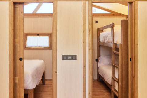 Interieur van Glamping Tent Alhamilla met tweepersoonsbed en stapelbed bij TAIGA Almeria Playa, Spanje.
