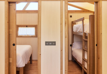 Interior de la Glamping Tent Alhamilla con cama doble y literas en TAIGA Almeria Playa, España.
