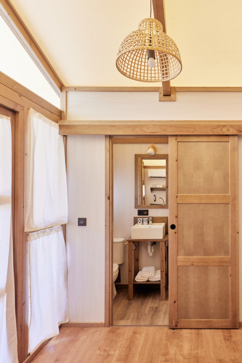 Innenansicht des Glamping Tent Alhamilla mit Holzmöbeln und Bad im TAIGA Almeria Playa, Spanien.