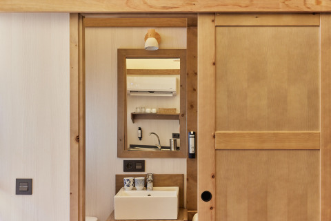 Reflection of a sink and wooden shelves in Glamping Tent Alhamilla at TAIGA Almeria Playa, Spain.