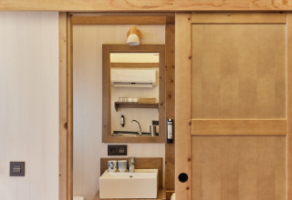 Reflection of a sink and wooden shelves in Glamping Tent Alhamilla at TAIGA Almeria Playa, Spain.