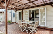 Terraza exterior con muebles de madera en Bungalow Confort Baconé, TAIGA Delta de l'Ebre en España.