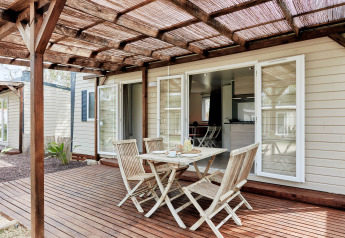 Terraza exterior con muebles de madera en Bungalow Confort Baconé, TAIGA Delta de l'Ebre en España.