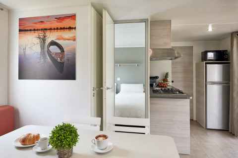 Modern bungalow-interieur bij Bungalow Confort Baconé, TAIGA Delta de l'Ebre, Spanje, met keuken en bed.