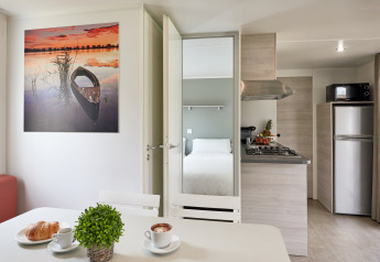 Moderne bungalow-indretning i Bungalow Confort Baconé, TAIGA Delta de l'Ebre, Spanien, med køkken og soveværelse.