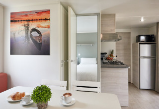 Helle, moderne Lodge Bungalow Confort Baconé im TAIGA Delta de l'Ebre, Spanien, mit Küchen- und Essbereich.