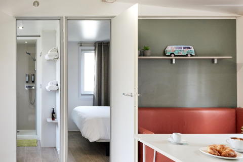 Modern interieur van Bungalow Confort Baconé in TAIGA Delta de l'Ebre met slaapkamer, badkamer en salonhoek.