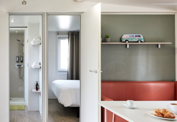Interior moderno del Bungalow Confort Baconé en TAIGA Delta de l'Ebre, con dormitorio, baño y zona de estar.