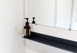 Modernes Waschbecken mit Spiegel und Seifenspender im Bungalow Confort Baconé, TAIGA Delta de l'Ebre, Spanien.