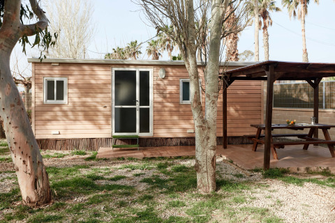 Cabaña de madera Bungalow Essential Banya con terraza cubierta, mesa de picnic y zona ajardinada verde