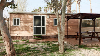 Cabaña de madera Bungalow Essential Banya con terraza cubierta, mesa de picnic y zona ajardinada verde