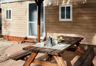 Holztisch mit Kaffee und Früchten vor einer Kabine im Bungalow Essential Banya, TAIGA Delta de l'Ebre, Spanien.