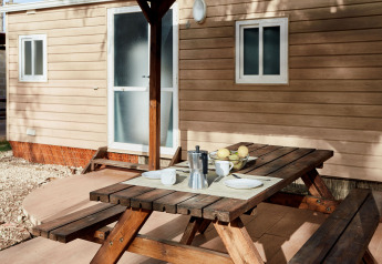 Table de pique-nique avec café et fruits devant un bungalow à TAIGA Delta de l'Ebre, Espagne.