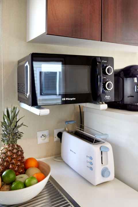 Coin cuisine du Bungalow Essential Golero avec micro-ondes, grille-pain et corbeille de fruits, TAIGA Delta de l'Ebre.