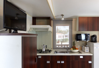 Moderne keuken in Bungalow Essential Golero bij TAIGA Delta de l'Ebre, Spanje, met toestellen en fruitschaal.