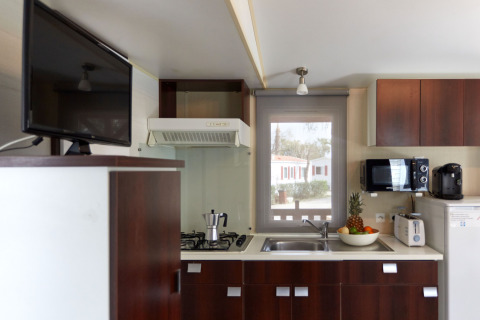 Cocina moderna en Bungalow Essential Golero de TAIGA Delta de l'Ebre, España, con electrodomésticos y frutero.