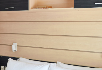 Foto interior de Bungalow Confort Delta con paneles de madera, almohadas blancas y armarios abiertos.