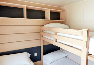 Habitación luminosa con litera y cama individual en Bungalow Confort Delta, TAIGA Delta de l'Ebre, España.