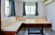Lyst og enkelt opholdsrum i Bungalow Essential Flamenc, TAIGA Delta de l'Ebre, med sofa og bord.