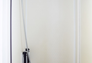 Douche dans la salle de bain minimaliste du Bungalow Essential Flamenc à TAIGA Delta de l'Ebre, Espagne.