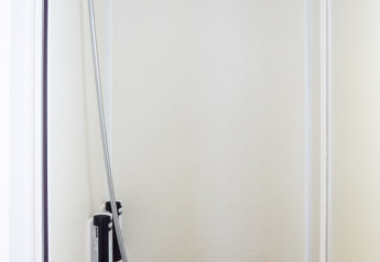 Douche dans la salle de bain minimaliste du Bungalow Essential Flamenc à TAIGA Delta de l'Ebre, Espagne.