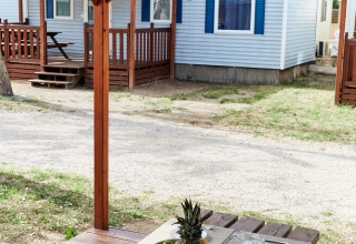 Buiten houten tafel onder overkapping bij Bungalow Confort Daurada, TAIGA Delta de l'Ebre, Spanje.