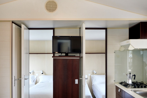 Interieur van Bungalow Confort Daurada bij TAIGA Delta de l'Ebre, Spanje, met slaapkamers en keuken.