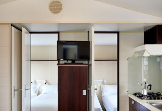 Interieur van Bungalow Confort Daurada bij TAIGA Delta de l'Ebre, Spanje, met slaapkamers en keuken.