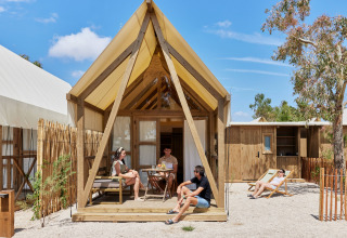 Vier mensen genieten bij een Glamping Cabin-Tent Senyoret bij TAIGA Delta de l'Ebre in Spanje.
