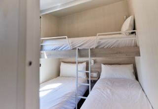 Camera del Bungalow Premium Gregal con letto a castello e due singoli a TAIGA Delta de l'Ebre, Spagna.