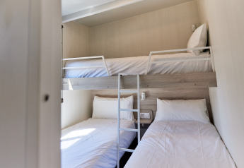 Kamer in Bungalow Premium Gregal met stapelbed en twee eenpersoonsbedden bij TAIGA Delta de l'Ebre, Spanje.