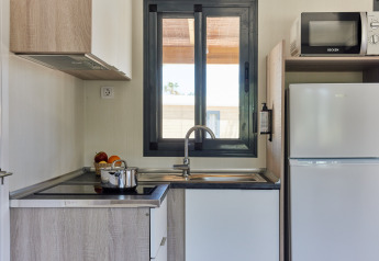 Cocina moderna en Bungalow Premium Ebre en TAIGA Delta de l'Ebre, España, con ventana, estufa y nevera.