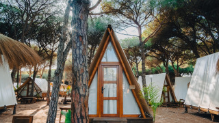 Accogliente chalet Glamping Tipi Pinar nel bosco, circondato da alberi e altre tende simili.