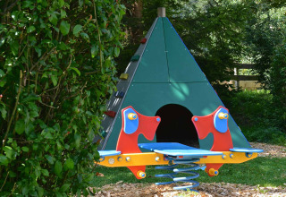 Speelplek in Drau Camping Sachsenburg, Karinthië, met bont wipplankje en groene tipi voor kinderen.