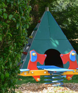 Spielplatz im Drau Camping Sachsenburg, Kärnten, mit bunter Wippe und grünem Tipi-Zelt.