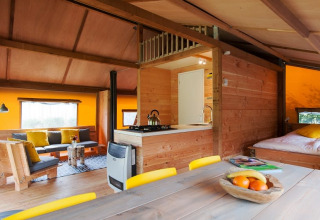 Interior de tienda safari Barntent en FarmCamps BoeBaDoe, Países Bajos, con decoración de madera acogedora.