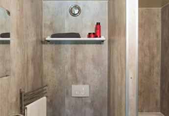 Foto van een compacte badkamer in een safaritent met toilet, wastafel, plankje en bad.