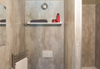 Photo d’une petite salle de bain sous tente safari avec toilettes, lavabo, étagère et baignoire.