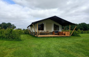 A holiday cabin at Boerderijcamping het Katreel, Overijssel, Netherlands, set in a lush green field.